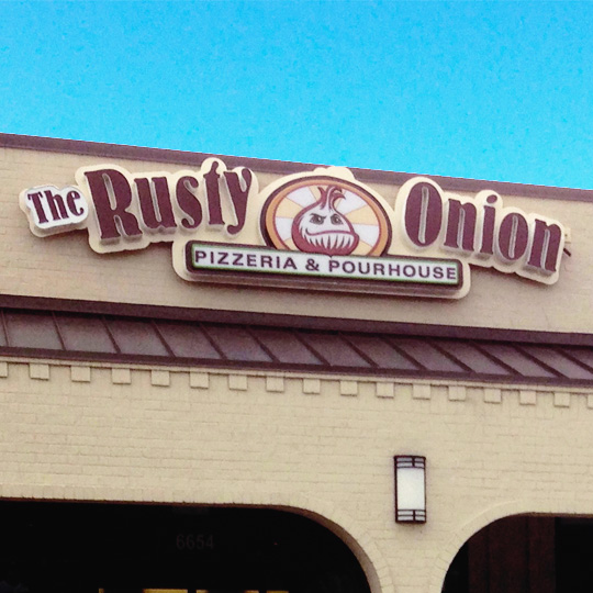 An outdoor vacuform-face LED building sign depicting an illustrated onion and the words'The Rusty Onion Pizzeria and Pourhouse'