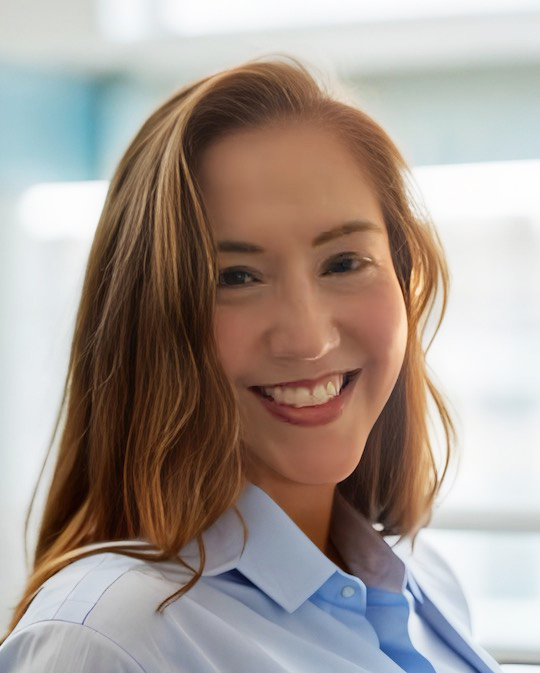 Image on Lindy Hues in a corporate setting, wearing a blue button-down shirt